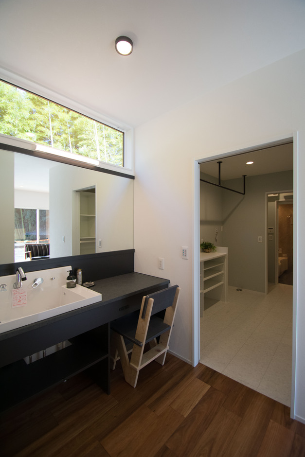 竹林を借景として取り入れた洗面所。造作洗面台は、清潔感のあるクールな印象に。