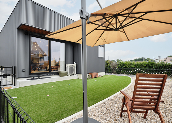 建物の道路側には窓を極力設けずクローズさせた一方、庭は広いスペースを確保して開放的なつくりに。ワンちゃんが自由に遊べるよう、庭の周りはフェンスで囲ってある