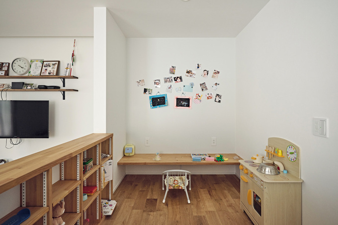 小上がりのキッズコーナーは、造作のカウンターと収納棚付き。絵本やおもちゃを整理整頓してしまえる。リビングやダイニングとの仕切り壁を低めにして圧迫感を排除。いつでも家族と会話でき、室内から子どもの様子もよくわかる