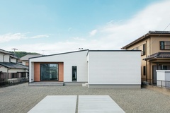シンプルでモダンなデザインの平屋の外観。白い壁と木材のアクセントが調和し、周囲の自然とも融合した美しい住まい。【TOZAKI HOME 戸﨑建設　】