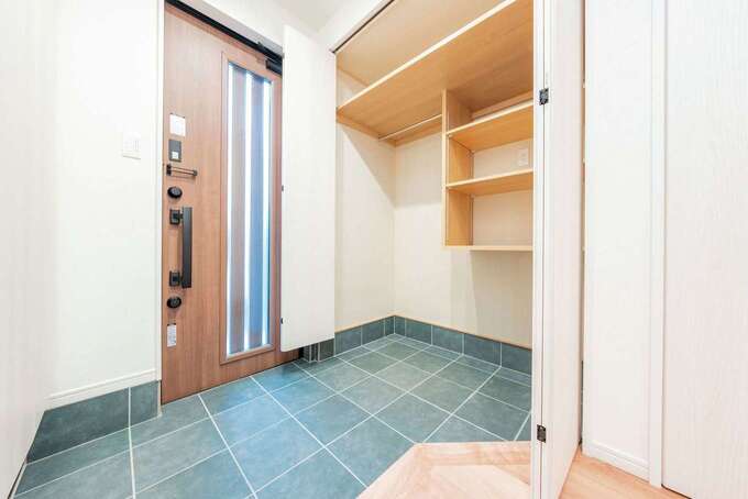 玄関の土間収納は雨具やコートが掛けられるクロークスタイルに。ベビーカーや子どもの自転車も収納できる