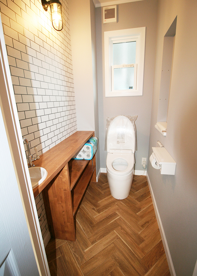 トイレの床はクラシカルなテイストを演出するヘリンボーン柄を採用。マリンランプの雰囲気ともマッチする