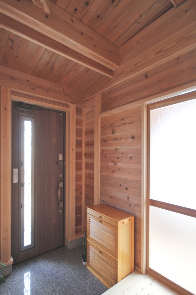 木材を贅沢に使用した玄関ホール。柔らかい光が差し込み、温かみのある自然な風合いが魅力的である。