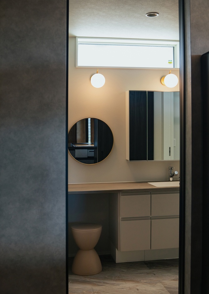 メイクもできる広い造作洗面台。北面でもハイサイドライトから柔らかな光が差し込み、十分な明るさをキープ。扉を開放すればリビングのエアコンが循環し、快適に過ごせる