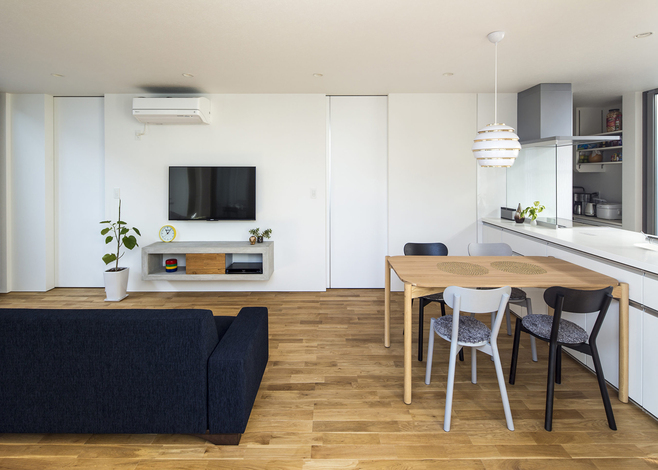 無駄を徹底して排除したシンプルなLDK。建具もキッチンに合わせて白を採用し、すっきりと仕上げた