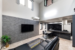 リビングのテレビ背面の壁は調湿消臭効果があるタイル「エコカラット」仕上げ。高窓のブラインドは電動式を採用。