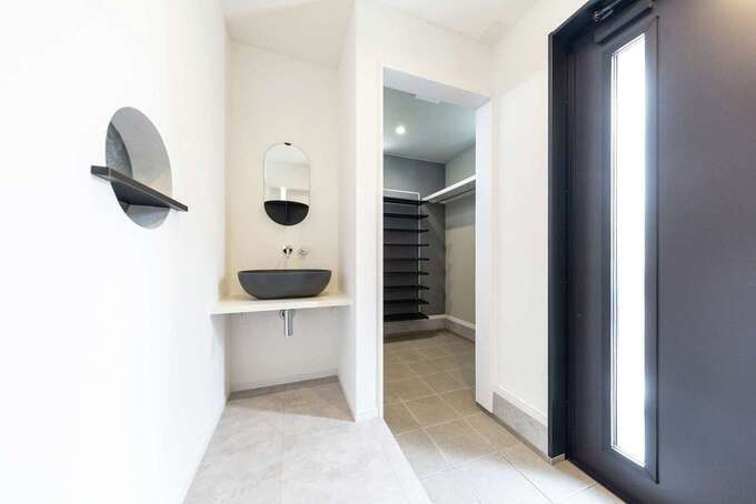 玄関ホールの手洗いもスタイリッシュなデザインに。シューズクロークはたっぷりの靴も収納可能