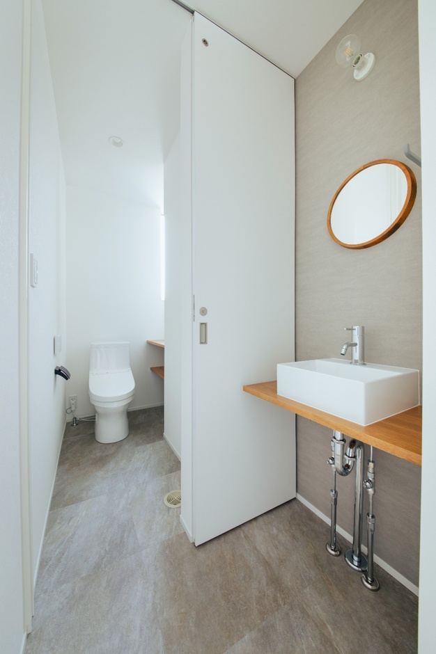 シンプルで機能的なトイレ空間。手洗い場も併設されており、使いやすさに配慮したデザインが魅力。明るいカラーで清潔感を演出。