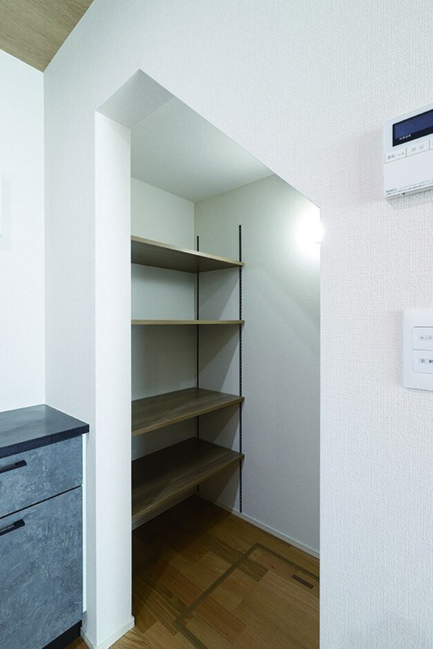 小屋裏へ続く階段下スペースを活用し、キッチン横にパントリーを設計。
リビングから中が見えない角度のため、「ここに詰め込むだけでお客様からは見えません（笑）」と奥さま