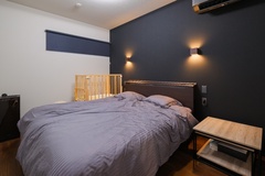 モダンなデザインの寝室。落ち着いたトーンの壁がリラックスムードを演出し、快適な睡眠をサポート。