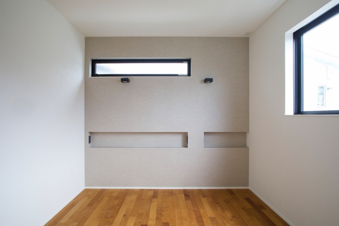 シンプルでモダンな居室の空間。壁面にはニッチを作成し、本やライトを置く、携帯の充電スペースとして活躍する。