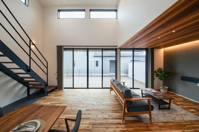 木目が美しい天井と床が、リビングに落ち着いた雰囲気をもたらしている。吹き抜けにより、空間全体に開放感が広がり、心地よいくつろぎを感じられる
