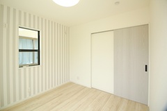 明るい色調の子ども部屋。シンプルな壁紙とスライド式のドアが特徴で、家具の配置がしやすい。自然光が差し込む窓も魅力的。【小野田産業～designers house project～】