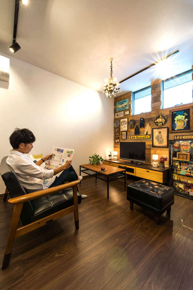 1階南側に設けたリビング。道路に面しているため、プライバシーの保護から窓は採光に必要充分なサイズの高窓に。壁には古材を用いて好みのインテリアを楽しんでいる
