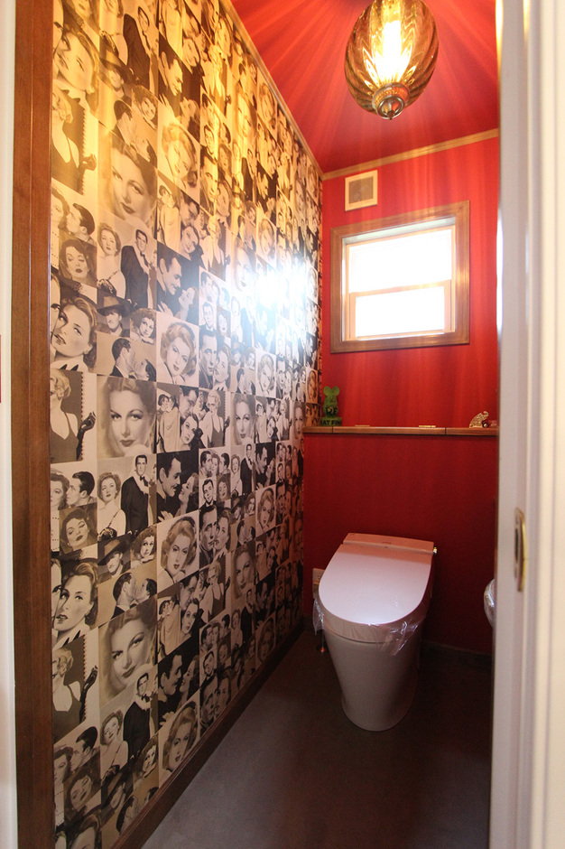 往年のハリウッドスターをコラージュした壁紙などを取り入れ、遊び心たっぷりに仕上げたトイレ