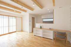 ナチュラルな木目が印象的なカバ無垢材の床と現しにした梁。南に大きく開いた窓からは造作の障子越しにやさしい光が届けられ、奥さまの希望を叶える明るいLDKが実現した【近藤建設工業】