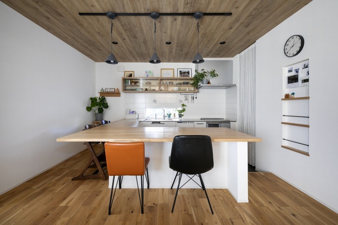 ナチュラルな木調が魅力的なダイニング。広々としたカウンターには椅子が二脚置かれ、簡単に食事や作業ができる。天井の照明が落ち着いた雰囲気を演出している。