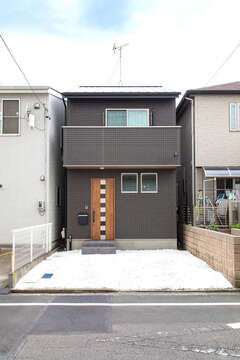 外観は黒を基調に玄関ドアや軒天井に木調を用いてナチュラルさをプラス。隣家との隙間はわずか40cmほど。これが『建築システム』が誇る隙間職人の実力