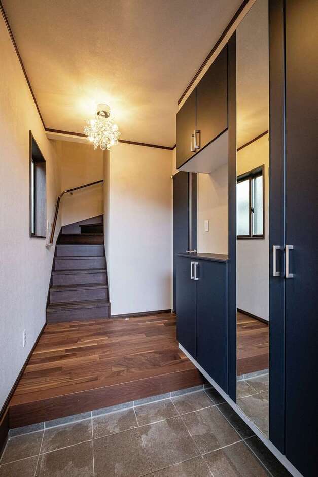 天井まで届く鏡が空間の広がりを感じさせる玄関ホール