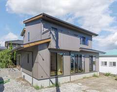 グレーの外壁がオリジナリティを表現するH邸。太陽光発電＋蓄電池を搭載したことで、電力の“自給自足”が可能に。同社独自のネットワークにより、これらのECOデバイスもリーズナブルに導入することができた【住まいるコーポレーション】
