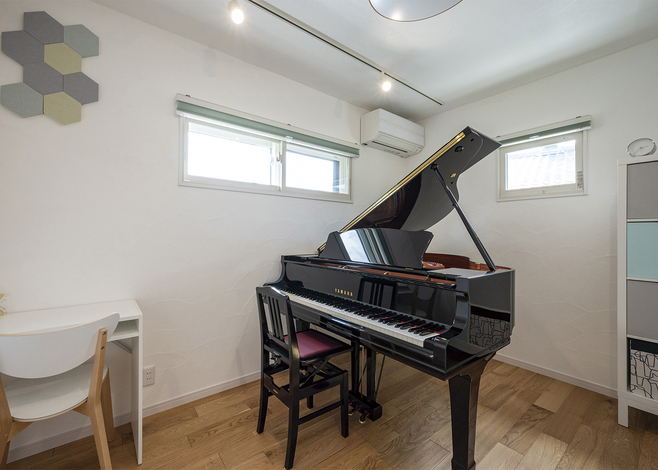ピアノ教室は部屋の周りをナチュラルな断熱材「セルロースファイバー」でぐるりと囲んだ防音室になっている。床は標準仕様でも「剛床」という強い工法でつくられているため、ピアノを置いても問題なし。素材は無垢オーク