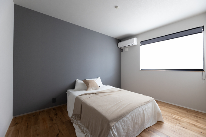 落ち着きあるグレーのアクセントクロスを採用したシンプルなベッドルーム。