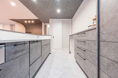 キッチンも上質感を醸すグレーを採用。白を基調とした空間に映える。隣には扉付きのパントリーを用意。必要なものにさっと手が届く距離が使いやすい【大成工務店】
