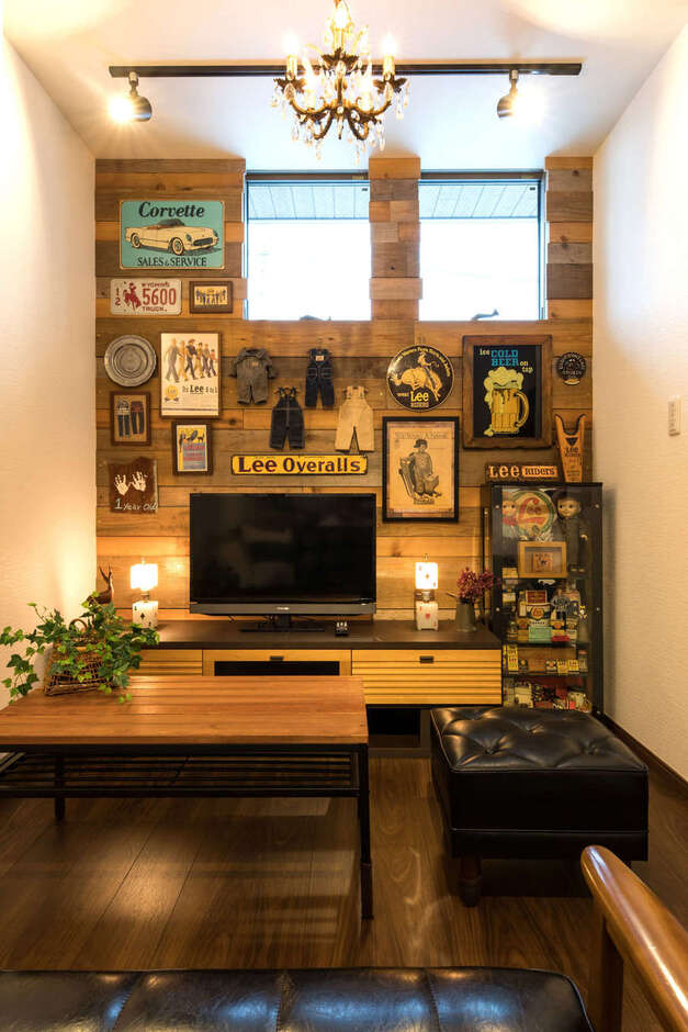 古材を張ったリビングの壁面。ご主人の大好きなアメリカンアンティークのコレクションをディスプレイ。シャンデリアも空間にマッチしている