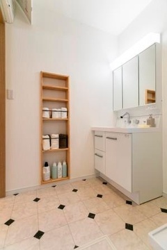 明るくシンプルな洗面スペース。収納棚が完備されており、生活用品をすっきりと収納できる。