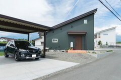 片流れの勾配屋根が印象的な外観。モスグリーンのガルバリウム外壁を採用し、海外のような趣