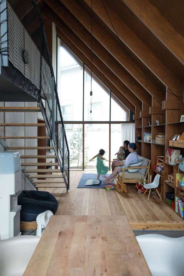 建杜 KENT（大栄工業）｜大きな三角屋根の半分は吹き抜け。家の南北がガラス張りになっているため、朝、自然の光が目覚めを誘う。杉の無垢材とモルタル、アイアンを使った、裸足で過ごせる家は素材の経年変化も楽しみだ。壁面はすべて、構造体のパネルを活用したオープンシェルフになっている
