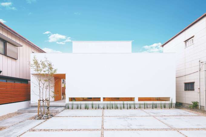 開口部を極力減らした、シンプルを極めたファサード。ポーチを抜けた先はテラスへと続く