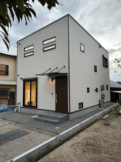 シンプルでモダンなデザインの外観。角張ったフォルムが特徴的で、スタイリッシュな印象を与える。白い壁が周囲の景観に自然に溶け込んでいる。【ユースタイルハウス　上村建設】