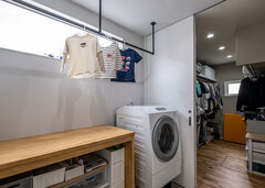 洗濯～乾燥まで、一か所で完結する脱衣所兼ランドリールーム。作業台で畳んだら、そのまま隣のファミリークローゼットへ収納【R＋house御殿場（岳南建設）】