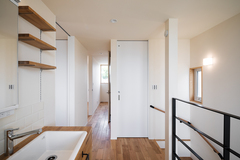 収納棚とシンクが備え付けられた洗面スペース。木の温もりを感じられるデザインが特徴的