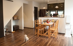 温かみのある木材を使用したダイニングスペース。中央に置かれたダイニングテーブルが家族の団らんを演出し、背後のキッチンも実用的に配置されている。