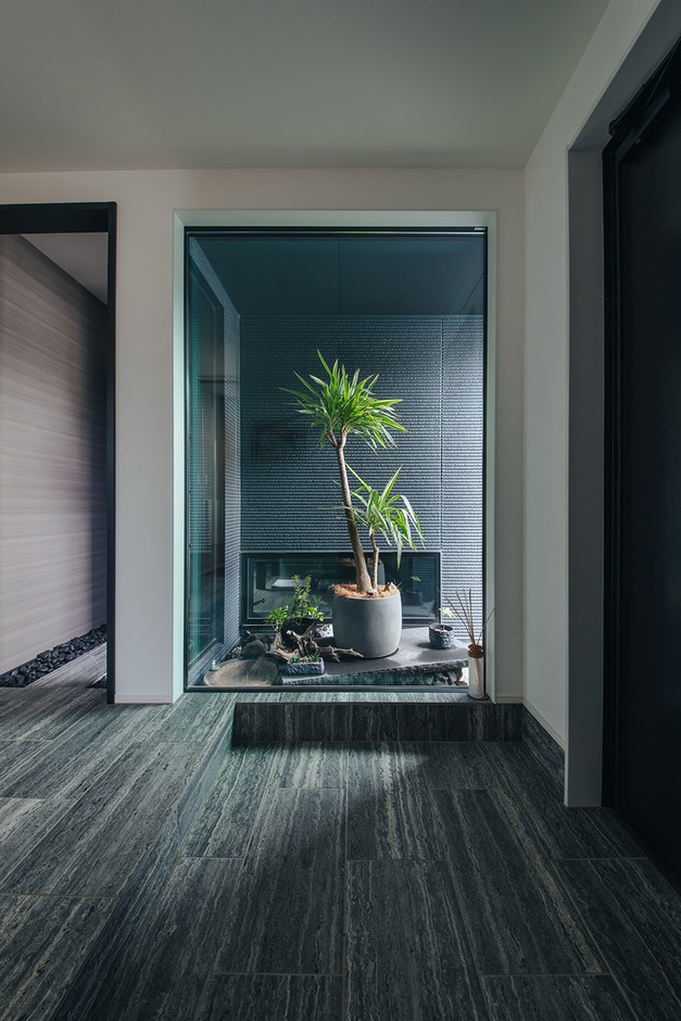 大きなFIX窓から中庭へと目線が抜ける玄関ホール。独創的な演出で非日常の空間ができあがった