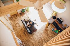 ロフトから見下ろすと、広々としたLDKが広がる。木目の無垢フローリングは素足で歩くのにとても気持ちが良いです。梁にターザンロープを結んで子どもが自由に遊べるリビングです。