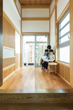 屋根勾配を活かした天井に、ガラス越しのシンボルツリー。床のチーク材はLDKより幅広の材料を使用している。敷台はタガヤサンの1枚板【櫻 工務店】