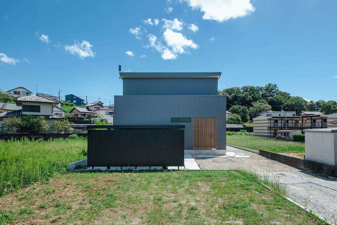 凸凹の少ない、シンプルな外観形状にしたことにより、建築費の節約につながる。外壁はメンテナンスしやすい高耐久ガルバリウム鋼板を採用し、ランニングコストを抑えた。玄関部分に木製ルーバーを設置し、外からの視線を遮る工夫も