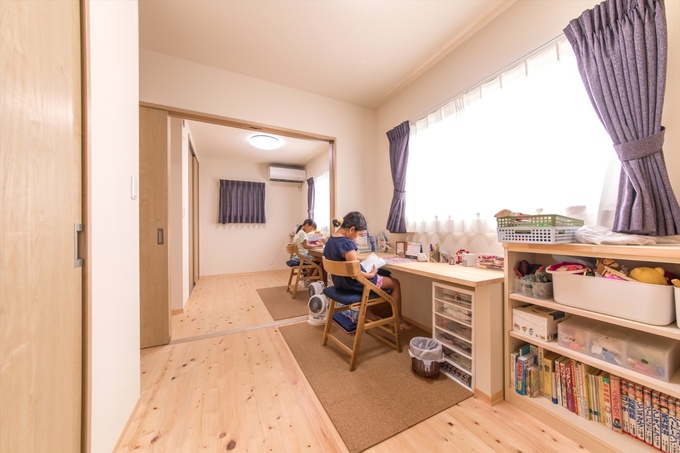 収納以外の建具はより開放的にする為に、全て引き戸を採用。２つの子ども部屋の間仕切りも引き戸にして、生活スタイルに合わせて開け閉めできるようにしました。子ども部屋の勉強机や本棚は造作で揃えてスッキリまとめています。