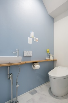 薄いブルーのアクセントクロスと白いフロアタイルで明るいトイレに。【シンプル】