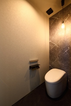 落ち着いた色合いのトイレ空間。石材調の壁が高級感を醸し出し、シンプルでありながら洗練されたデザイン。【REIWA HOUSE（令和ハウス）】