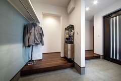 玄関は土間を広く取り、シューズクロークと外着を掛けるコーナーを確保【コットンハウス】