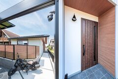木目調の玄関ドアと軒天が、白を基調としたシンプルな外観にあたたかみをプラス。
プライバシーを守る木目フェンスと、奥行のある直線の軒とアプローチが日常を心地よく演出します。【アッシュホーム】