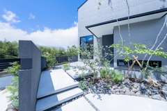 モダンな直線的デザインが際立つ建物の外観。手入れの行き届いた植栽が住宅の美しさを引き立てている。