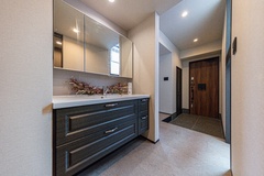 洗練されたデザインの玄関ホール。広々とした空間に大きなミラーが配置され、明るさと開放感を演出している。