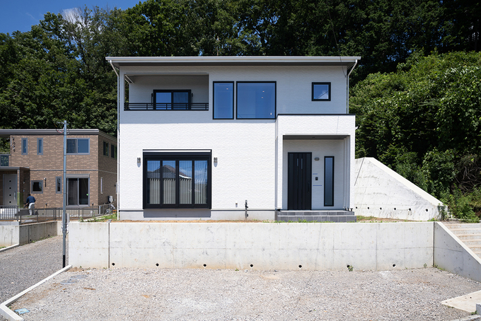 山の緑をバックに美しく映える白亜の外観。自社ブランド「Haqua（ハクア）」は、建物の大きさによって価格が決まる定額制。建物のほか、付帯工事費、諸費用も含まれるので家づくりの総額がわかりやすい