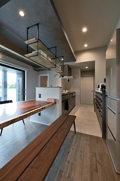 モダンなデザインのキッチン空間。手元を隠す工夫がなされており、カフェ風の収納が視覚的に楽しめる作りになっている。