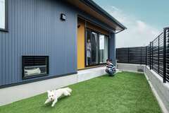 人工芝の庭はドッグランとして大活躍。愛犬リバちゃんも嬉しそうに走り回る。フェンスで目隠ししてあるので、視線を浴びることなくBBQも子どもプールも楽しめる【ぽっくハウス伊豆半島店（島崎創建）】